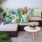 Funda de cojín hojas tropicales con distintos diseños botánicos en sofá de terraza